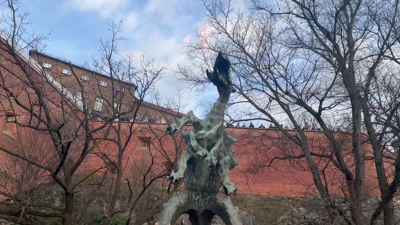 The fire-breathing Wawel Dragon statue below Wawel Castle