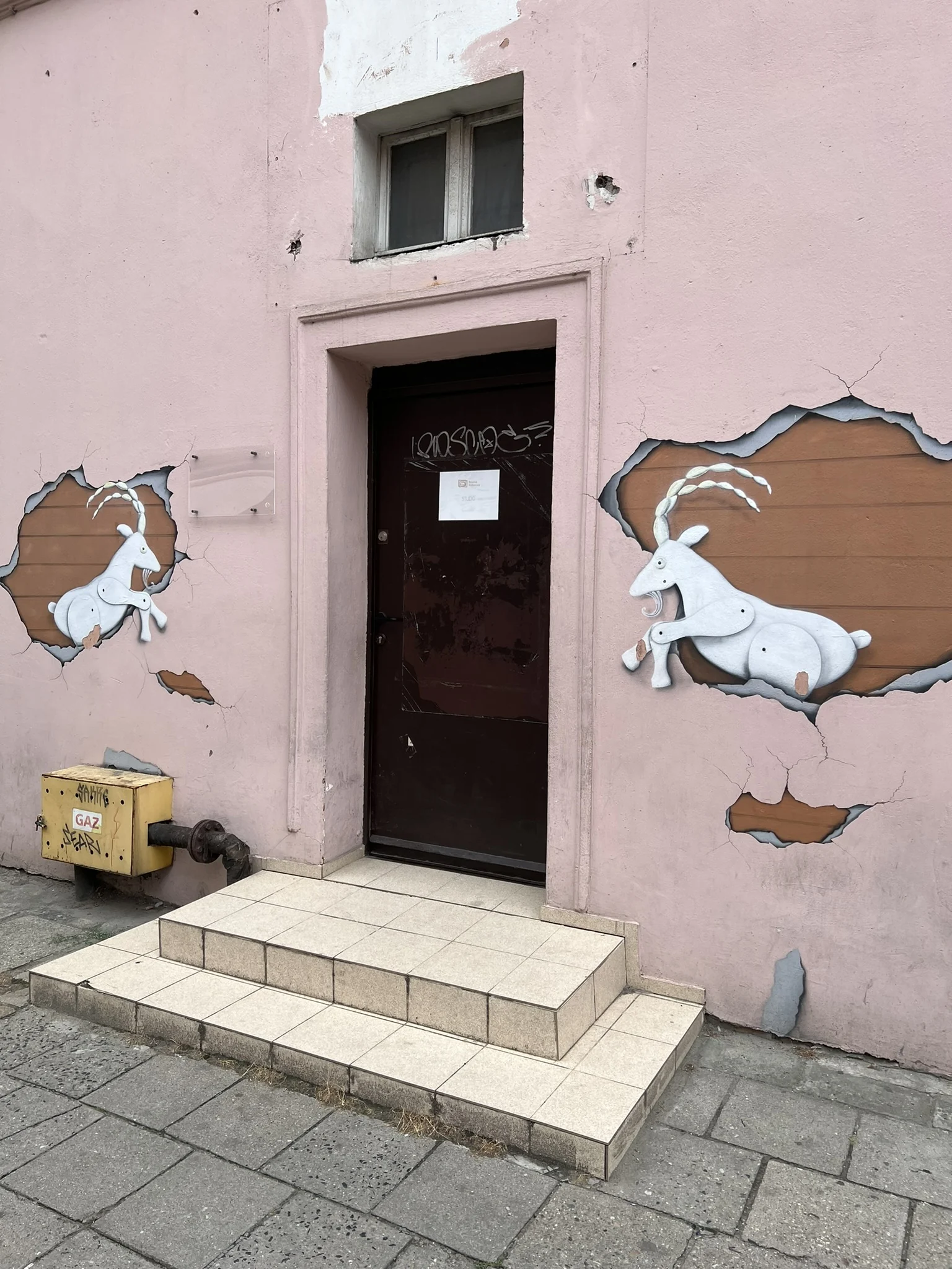 Two stylised goats on a mural photographed in Poznań
