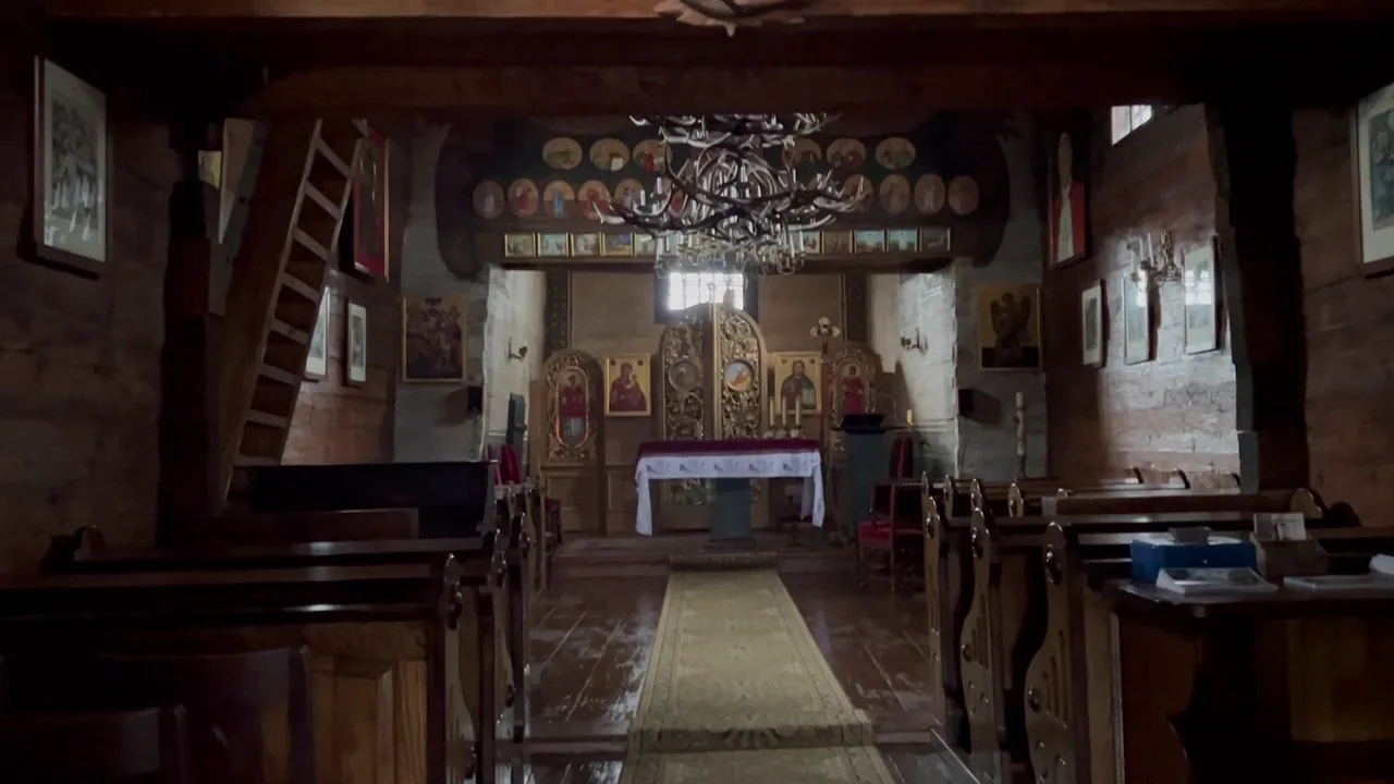 A small wooden church interior at Lutowiska, with timber walls, pews and sanctuary.
