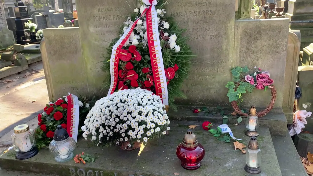 White chrysanthemums and remembrance wreaths laid at a Polish grave