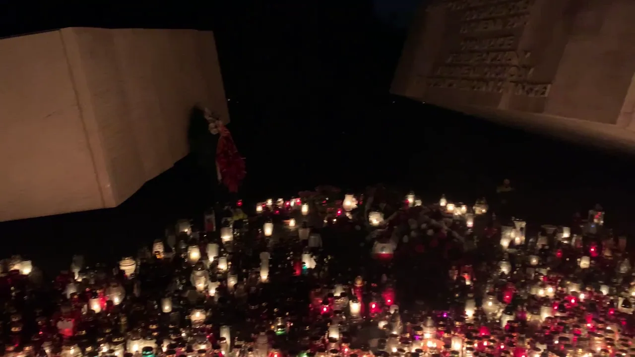 Close view of densely arranged red and white grave candles shining after dark