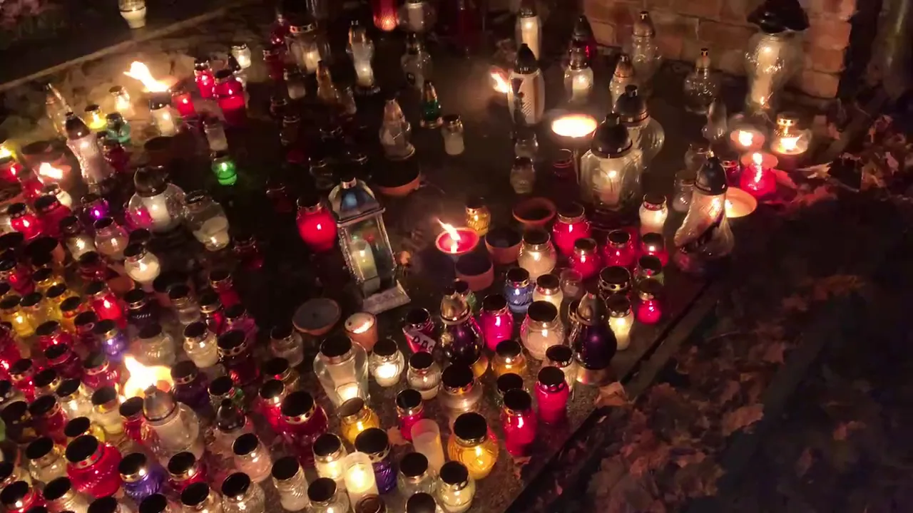 Hundreds of colourful memorial candles illuminating a Polish cemetery at night