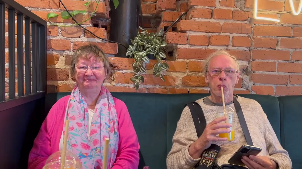 The creator's parents sitting together in a café