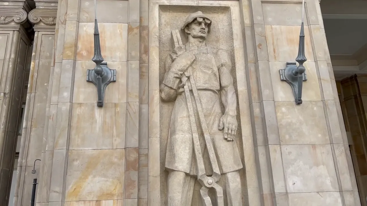 A sculpted worker relief on a Socialist Realist building