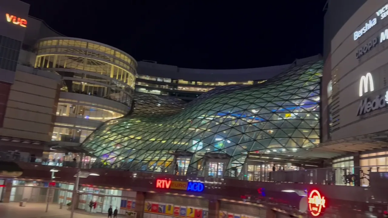 The sweeping glass roof of Złote Tarasy illuminated at night